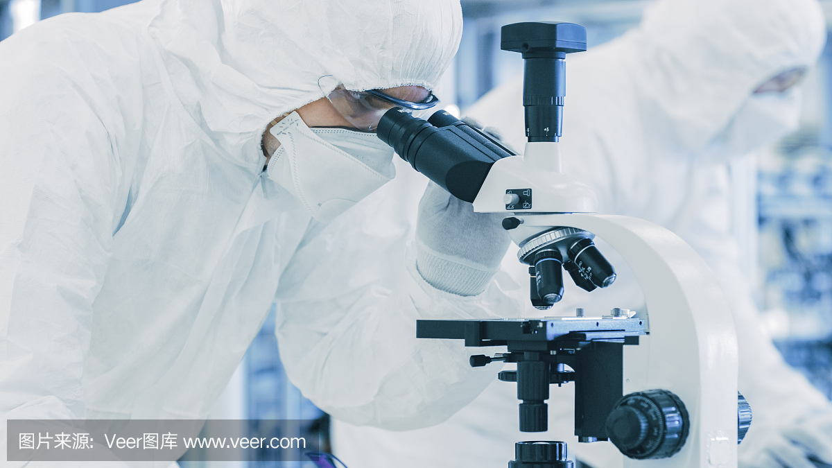 在实验室科学家穿着防护服做研究,使用显微镜和记录数据。工人在一个现代制造生产半导体和药品。